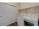 This is a bright laundry room with modern washer and dryer and storage shelves at 152 Ambrose St, Erie, CO 80516