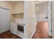Modern laundry area featuring a side-by-side washer and dryer and an open storage shelf at 152 Ambrose St, Erie, CO 80516