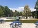 Community pool area featuring an in-ground pool, seating, picnic tables, and lush landscaping at 152 Ambrose St, Erie, CO 80516