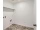 Well-lit laundry room with white walls, overhead shelf, and tile flooring at 4588 Thistle Dr, Brighton, CO 80601