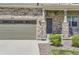 Inviting front entrance with stone detailing, covered porch, and well-manicured landscaping at 417 S Ouray St, Aurora, CO 80017