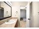 Bathroom vanity features a large mirror and granite countertop, opening to a bedroom at 20389 E Powers Pl, Centennial, CO 80015