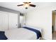 Bright bedroom features a ceiling fan, closet, and cozy bed with a blue throw blanket at 20389 E Powers Pl, Centennial, CO 80015
