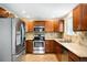 Spacious kitchen featuring stainless steel appliances, wood cabinets, and tile backsplash at 20389 E Powers Pl, Centennial, CO 80015