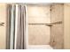 Shower features neutral stone tile work, built-in shelf, and a gray shower curtain at 20389 E Powers Pl, Centennial, CO 80015