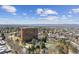 Scenic aerial view of the property, highlighting its prime location near lush greenery, tennis courts, and cityscape at 1900 E Girard Pl # 907, Englewood, CO 80113