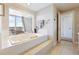 Luxurious bathtub with scenic window, tile surround, and plenty of space for relaxation with natural light at 1900 E Girard Pl # 907, Englewood, CO 80113