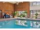 Indoor swimming pool area featuring natural light, brick accents, and lush greenery at 1900 E Girard Pl # 907, Englewood, CO 80113
