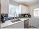 Well-lit kitchen with white cabinets, modern appliances, and a decorative tile backsplash at 500 S Pennsylvania St # 520, Denver, CO 80209