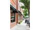 Street view of the building, displaying red brick construction and window awnings above the sidewalk at 500 S Pennsylvania St # 520, Denver, CO 80209