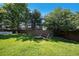 Spacious backyard with lush lawn, wooden fence, and a fire pit with bench seating at 9924 Silver Maple Way, Highlands Ranch, CO 80129