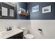 Charming powder room features white wainscoting, dark walls, and decorative mirror at 9924 Silver Maple Way, Highlands Ranch, CO 80129