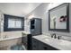 Bathroom featuring double marble sink vanity, a large tub, with tile flooring and a modern feel at 9924 Silver Maple Way, Highlands Ranch, CO 80129