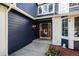 Inviting home entrance featuring stylish navy blue siding, white brick accents, and a charming red door at 9924 Silver Maple Way, Highlands Ranch, CO 80129