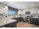 Modern kitchen with granite countertops, stainless steel appliances, and stylish cabinetry with white and gray accents at 9924 Silver Maple Way, Highlands Ranch, CO 80129