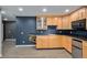 Kitchenette with natural wood cabinets, sleek black countertops, mini fridge, and stainless steel microwave at 9924 Silver Maple Way, Highlands Ranch, CO 80129