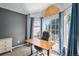Well-lit office space with a standing desk, ergonomic chair, large window, and blue curtains at 9924 Silver Maple Way, Highlands Ranch, CO 80129