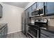Bright kitchen boasting modern appliances and painted blue cabinets at 3600 S Pierce St # 5-101, Denver, CO 80235