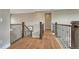 Elegant hallway showcasing hardwood flooring, iron railing, and stylish lighting fixtures at 11821 Discovery Ln, Parker, CO 80138