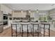 Stylish kitchen island with white cabinets, granite countertop, and seating for four at 11821 Discovery Ln, Parker, CO 80138