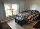 Cozy bedroom with a patterned bedspread, wood-look flooring, bench and a bright window at 2111 Enterprise St, Superior, CO 80027