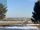 Serene community view with benches, lush greenery, and distant cityscape under a clear blue sky at 2111 Enterprise St, Superior, CO 80027
