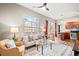 Cozy living room features large windows, stylish furniture, modern ceiling fan, and an open floor plan to the kitchen at 5401 S Park Terrace Ave # 105A, Greenwood Village, CO 80111