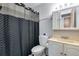 Well-lit bathroom with vanity, toilet, and patterned shower curtain at 15628 E Girard Pl, Aurora, CO 80013