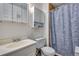 Traditional bathroom with white fixtures and blue patterned shower curtain at 15628 E Girard Pl, Aurora, CO 80013