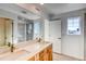 Bright bathroom featuring a large mirror, double vanity, and a window with neighborhood views at 21292 E 63Rd Dr, Aurora, CO 80019
