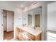 Bathroom featuring a dual-sink vanity with modern fixtures, a large mirror, and walk-in closet at 21292 E 63Rd Dr, Aurora, CO 80019