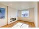 Bright living room with modern fireplace, hardwood floors, and large window views at 21292 E 63Rd Dr, Aurora, CO 80019