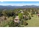 Aerial view of a mountain home with mature trees, landscaping, and scenic surroundings at 1621 Baneberry Ln, Golden, CO 80401