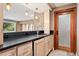Home bar with black countertop, wood cabinets, and stylish pendant lighting at 1621 Baneberry Ln, Golden, CO 80401