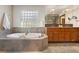 Bathroom featuring a soaking tub and a double sink vanity with a large mirror at 1621 Baneberry Ln, Golden, CO 80401