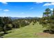 A picturesque landscape with lush greenery, mature trees, and mountain views at 1621 Baneberry Ln, Golden, CO 80401