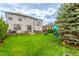 Spacious backyard showcasing lush green lawn and a charming playset near the home at 12330 Village E Cir, Commerce City, CO 80603
