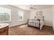 Bright bedroom with large windows, ceiling fan, and neutral decor for flexible design options at 12330 Village E Cir, Commerce City, CO 80603