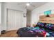 Modern bedroom featuring a gamer theme decor, ceiling fan, and ample closet space at 12330 Village E Cir, Commerce City, CO 80603