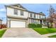 Well-maintained home with a two-car garage, driveway, manicured lawn, and welcoming front porch at 12330 Village E Cir, Commerce City, CO 80603