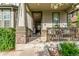 Inviting front porch features stone accents and a cozy seating area for relaxing outdoors at 12330 Village E Cir, Commerce City, CO 80603