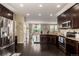 Open kitchen with stainless appliances, granite counters, dark wood cabinets and adjoining dining area at 12330 Village E Cir, Commerce City, CO 80603