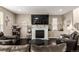 Comfortable living room featuring a fireplace, large television, and dark wood floors at 12330 Village E Cir, Commerce City, CO 80603