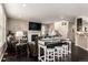 Open-concept living room with a fireplace, bar-style seating, and dark wood floors at 12330 Village E Cir, Commerce City, CO 80603
