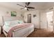 Bright bedroom features a ceiling fan, coastal decor, and an ensuite bathroom for added convenience at 12330 Village E Cir, Commerce City, CO 80603