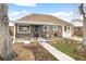 Traditional brick home featuring a landscaped front yard and covered porch at 875 S Dale Ct, Denver, CO 80219