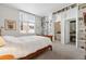 Bedroom with built-in shelves, a large window, and an ensuite bathroom, perfect for relaxation and privacy at 301 Garfield St # 1E, Denver, CO 80206