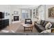 Comfortable living room with fireplace, built-in bookshelves, and ample natural light from large windows at 301 Garfield St # 1E, Denver, CO 80206