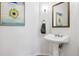 Elegant powder room featuring a pedestal sink, decorative mirror, and stylish artwork at 301 Garfield St # 1E, Denver, CO 80206