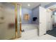Bright bathroom featuring a tub with tile surround, glass-enclosed shower, and tasteful blue wall decor at 5155 W Quincy Ave # 101, Denver, CO 80236